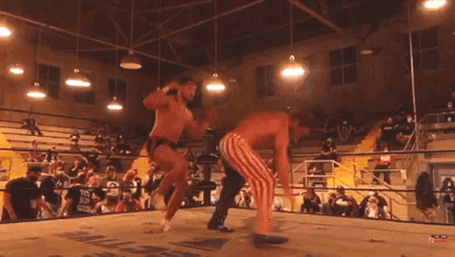 two men are wrestling in a ring with a sign that says wrestling