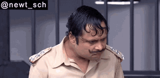 a man with a mustache is wearing a police uniform .