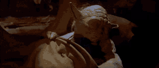a close up of a statue of yoda from star wars holding a pumpkin .