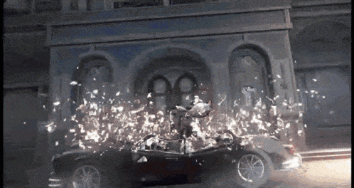 a car is being destroyed by a building with a lot of sparks coming out of it .