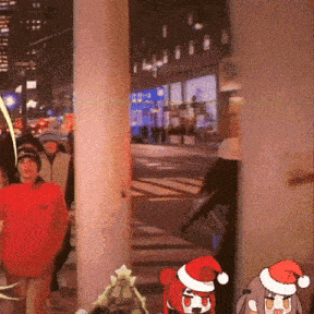 a group of people are walking down a street and one of them is wearing a red santa hat
