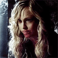 a close up of a woman 's face with long blonde hair and a bloody mouth .
