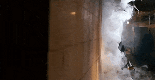 a person is standing in a room with smoke coming out of the window .