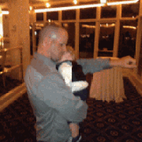 a man is holding a baby in his arms and pointing