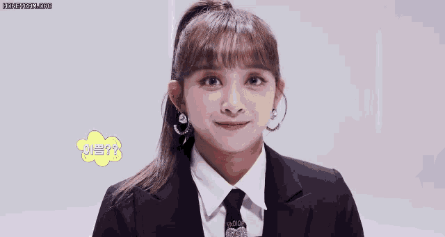 a girl in a suit and tie is smiling and talking .