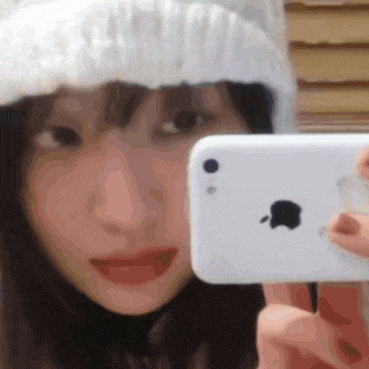 a woman in a white hat is taking a picture of herself with an apple phone