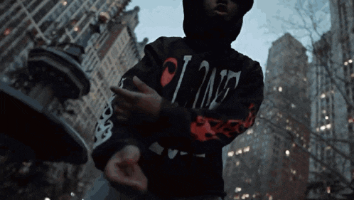 a person wearing a black hoodie that says vlone on it