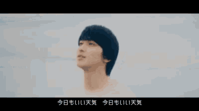 a man is standing on a beach with his eyes closed and looking up .