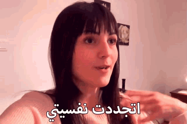 a woman in a pink sweater with arabic writing on the bottom