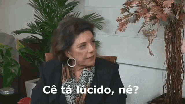 a woman is sitting in front of a plant with the words ce ta lucido ne written above her