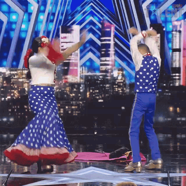 a man and a woman are dancing on a stage in front of a sign that says ' america ' on it