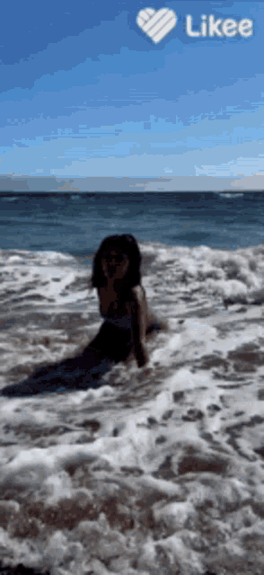 a woman in a mermaid costume is sitting in the ocean waves