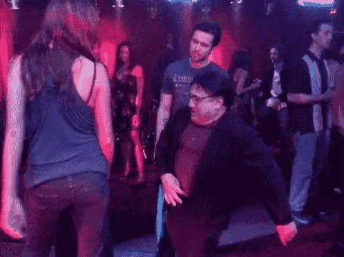 a man is dancing with a woman in a nightclub .