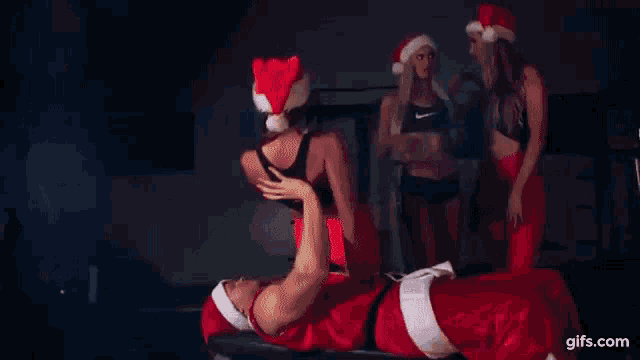a man in a santa hat is doing a handstand on a rope .