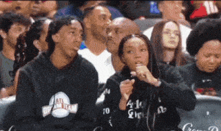 a group of people are watching a basketball game and one of them is wearing a hoodie that says all central