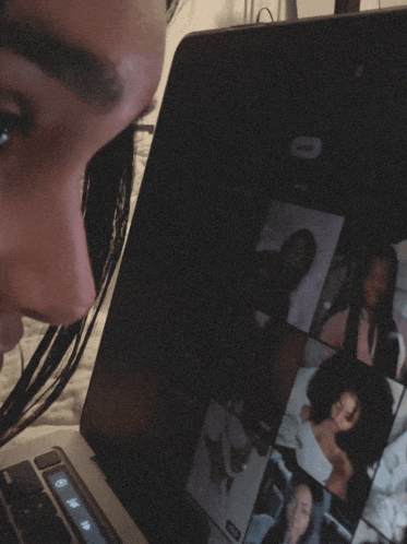 a woman is looking at a laptop screen that has a picture of a woman on it