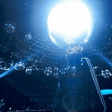 a man is holding a trophy in front of a crowd of people in a dark room .