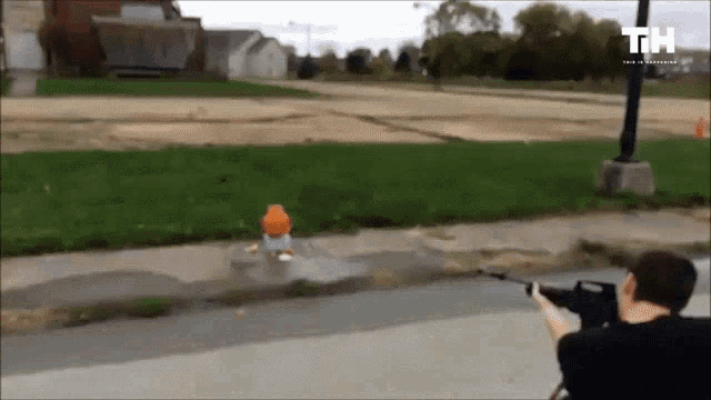 a man is holding a gun in front of a fire hydrant and a sign that says th