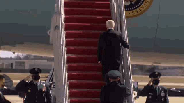 a man walks up the stairs of an airplane with the united states seal on the side