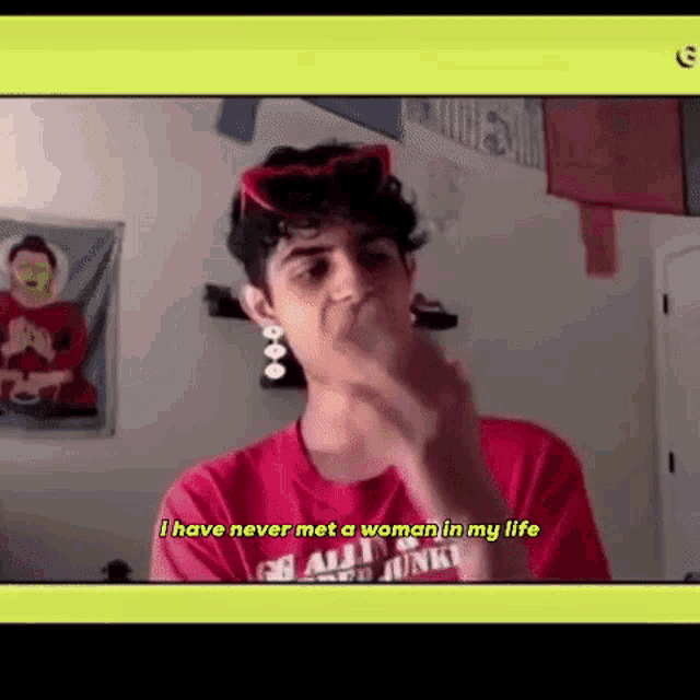 a man wearing a red shirt and sunglasses is making a funny face while talking on a video call .