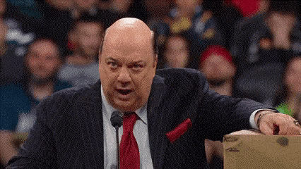 a bald man in a suit and tie is talking into a microphone .