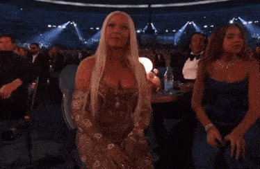 a woman in a dress is dancing in a crowd of people at a concert .