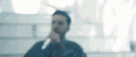 a blurry picture of a man singing into a microphone in a room .