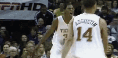 two basketball players are standing next to each other and one has the number 14 on his back .