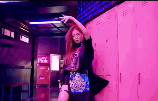 a woman is dancing in front of pink lockers .