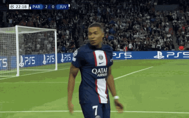 a soccer player wearing a qatar jersey stands on the field