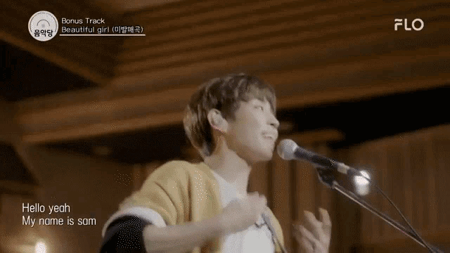 a young man is singing into a microphone and dancing .