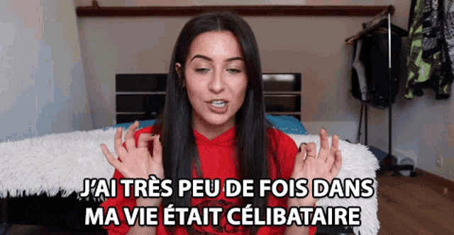 a woman in a red shirt is talking in french