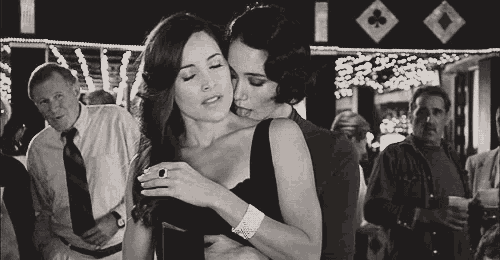 two women are hugging each other in a black and white photo .