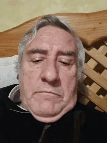 a close up of a man 's face with a black jacket on