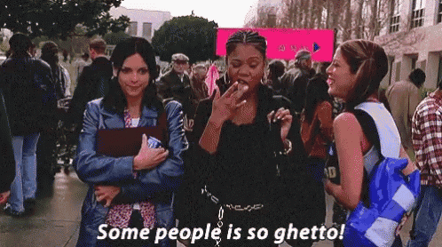 a woman smoking a cigarette while standing next to another woman with the words some people is so ghetto .