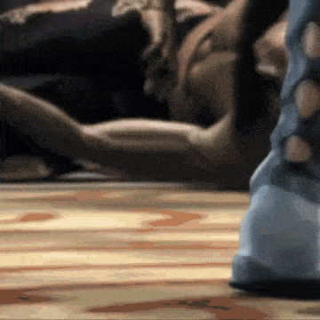 a person is laying on a wooden floor with their legs crossed .
