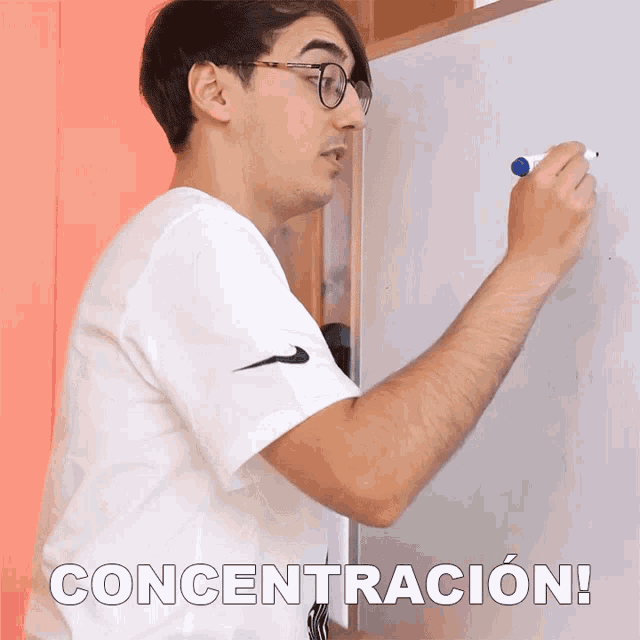a man writing on a white board with the word concentracion written on the bottom