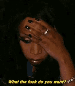 a woman is crying and covering her face with her hand and asking what the fuck do you want .