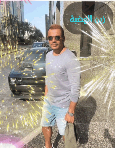 a man wearing sunglasses stands in front of a building that says ' arabic ' on it