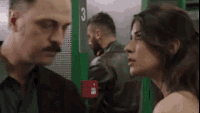 a man and a woman are standing next to each other in a room .