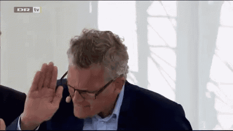 a man wearing glasses and a suit is giving a high five in front of dr tv