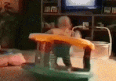 a baby is sitting in a high chair in front of a television .