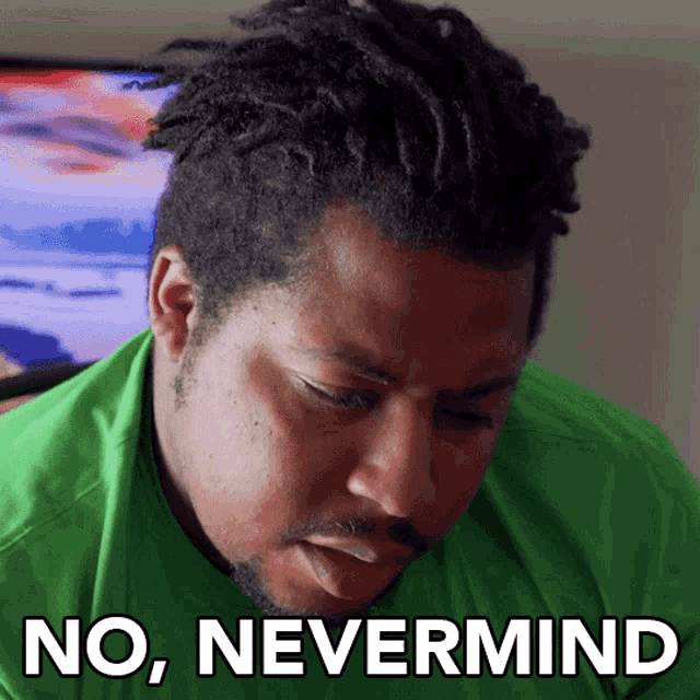 a man in a green shirt has the words no nevermind written on his face
