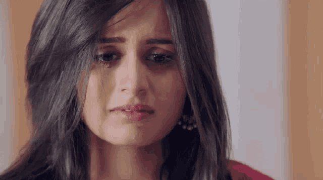 a woman is crying with a tear running down her cheek