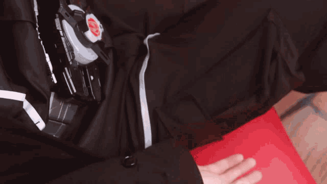 a person 's hand is reaching out towards a red item with the letter o on it