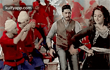 a man and a woman are dancing in front of a crowd .