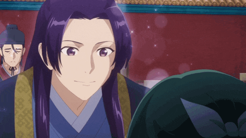 a man with long purple hair is standing in front of a red wall