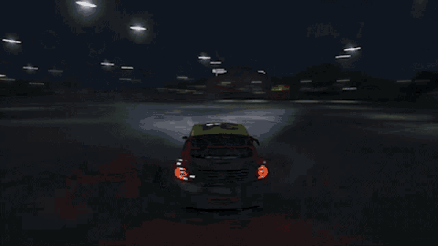 a yellow and red race car is driving on a snowy track at night