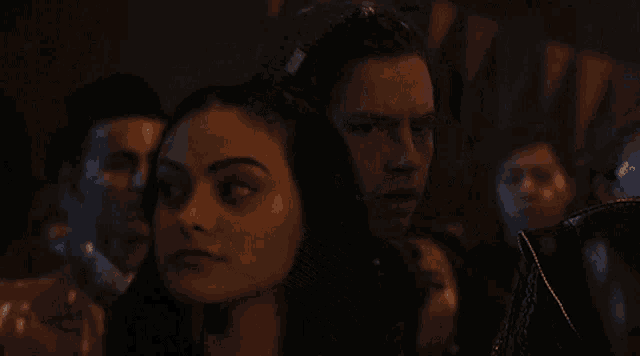 a man and a woman are kissing in a dark room