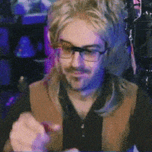 a man wearing a wig and glasses is sitting in front of a microphone